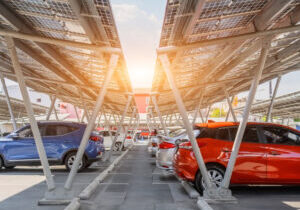 Solar panels installed over parking lot with parked cars for effective generation of clean energy.